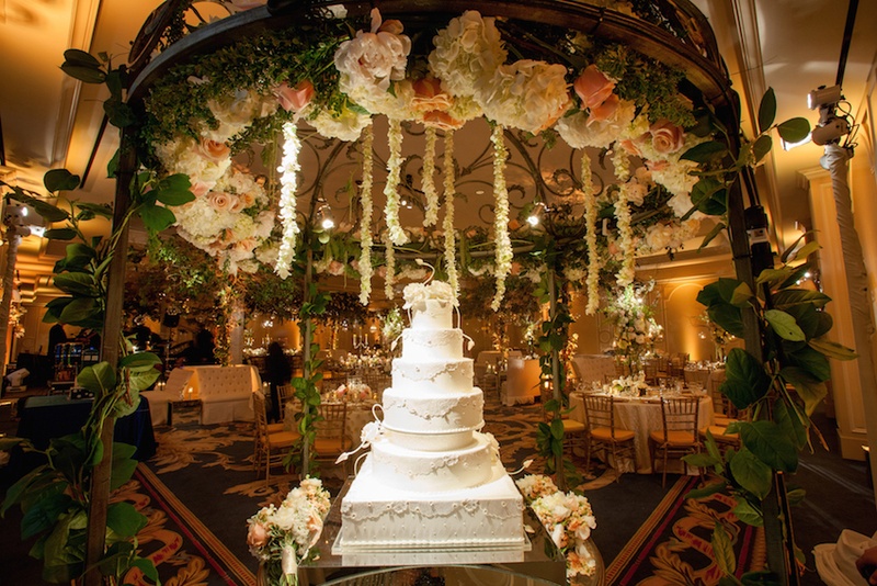 White Wedding Cake Under Flowers
Photography: Michael Carr Photography
Read More:
http://www.insideweddings.com/weddings/traditional-church-ceremony-forest-inspired-reception-in-houston/695/ White six layer wedding cake under wrought iron flower chandelier