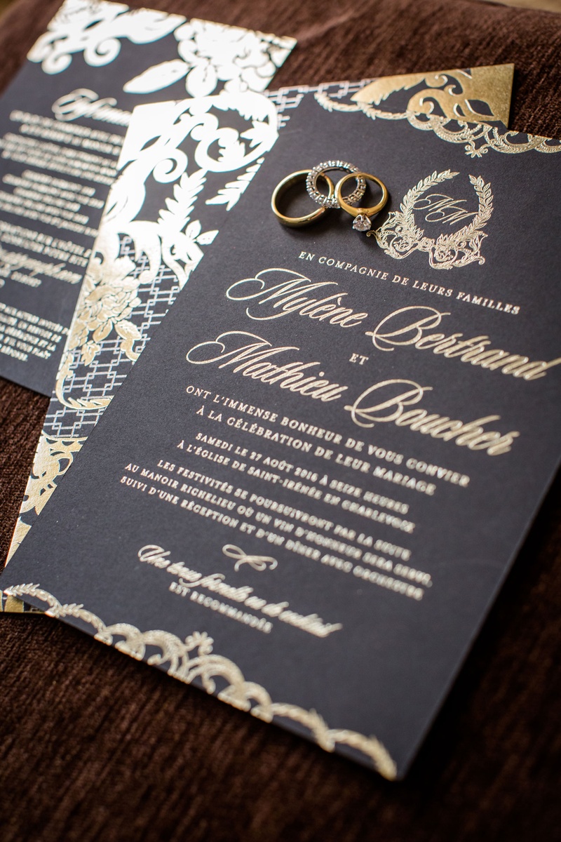 Gold Monogram %26 Script Invitation
Photography: Magnolia Studio
Read More:
http://www.insideweddings.com/weddings/charming-church-ceremony-romantic-ballroom-reception-in-quebec/1075/ Wedding invitation with wedding rings and band on top black stationery gold lettering and monogram