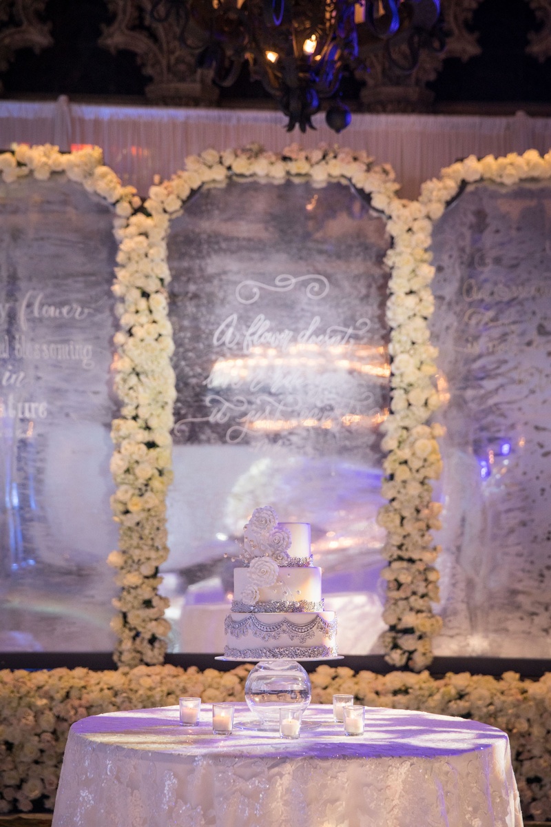Flower Quote Calligraphy Backdrop
Photography: Collin Pierson Photography
Read More:
http://www.insideweddings.com/weddings/winter-wedding-inspirational-shoot-with-opulent-frosted-decor/1108/ Wedding cake on cake table silver white in front of flower wall mirror quote etched white flowers
