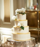 Classic Cake with Roses
Photography: Regeti's Photography
Read More:
http://www.insideweddings.com/weddings/elegant-wedding-with-ivory-gold-green-palette-in-washington-dc/1174/ Four layer wedding cake on silver cake stand white rose green leaves swiss dot gold border tiers