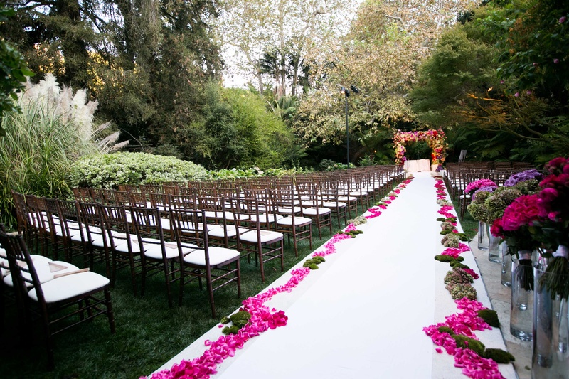 Vibrant Pink Flowers on Aisleway
Photography: Mi Belle Photographers
Read More:
http://www.insideweddings.com/weddings/colorful-outdoor-wedding-with-supper-club-theme-in-los-angeles-ca/741/ Hotel Bel-Air Swan Lake wedding ceremony with white aisle runner and bright pink flower petals