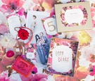 Chanel Paper Products Atop Pink Floral Table Linen