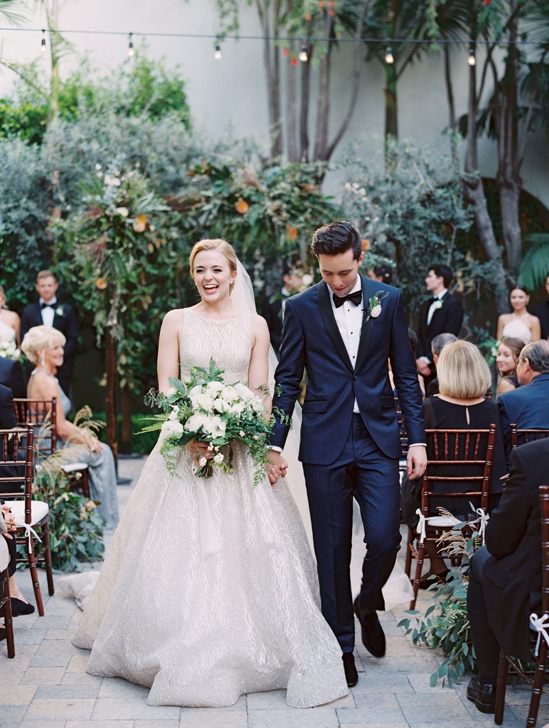 Happy Couple Walking Down Vibiana Aisle
Photography: Mallory Dawn Photography
Read More:
http://www.insideweddings.com/weddings/outdoor-jewish-ceremony-luxe-reception-at-vibiana-in-downtown-la/1259/ bride in sparkle lazaro wedding dress high neck updo green and white bouquet groom navy tuxedo