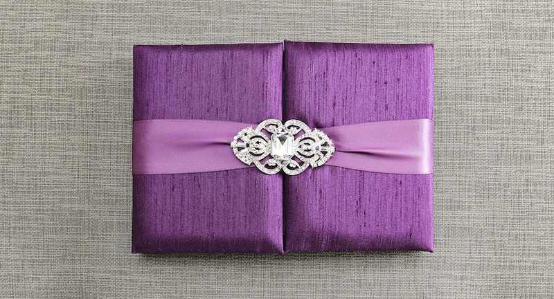 Silk Aubergine Gatefold Invitation Box
Photography: Carasco Photography
Read More:
http://www.insideweddings.com/weddings/city-wedding-at-chicago-planetarium-with-purple-yellow-palette/688/ Violet gatefold wedding invitation box with light purple ribbon, crystal brooch