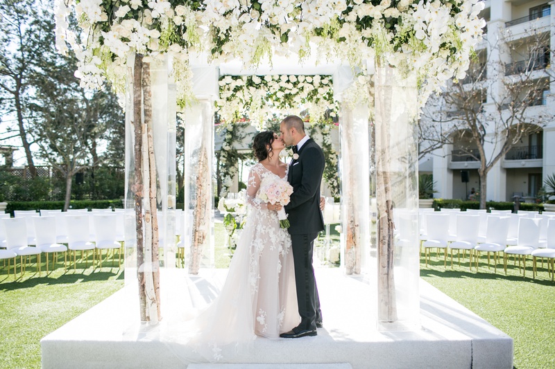 Bride %26 Groom Kiss Under Chuppah
Photography: Samuel Lippke Studios
Read More:
http://www.insideweddings.com/weddings/outdoor-jewish-wedding-ceremony-luxe-reception-in-california/1160/ Tree branch chuppah with lucite structure white flowers greenery orchids roses kiss couple