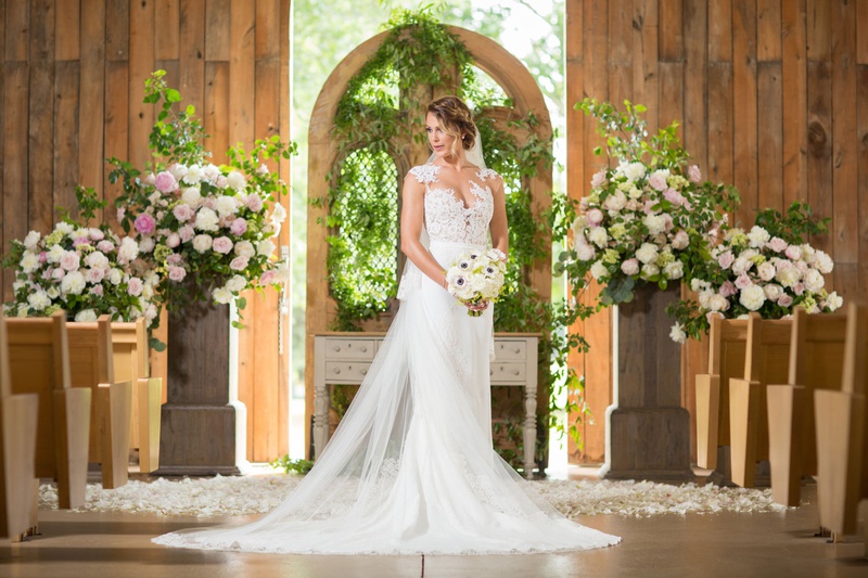 Bride at the Altar
Photography: Little Tree Studios
Read More:
http://www.insideweddings.com/weddings/brian-winters-of-the-new-york-jets-romantic-rustic-chic-wedding/1245/ bride in pronovias gown with illusion neckline lace bodice, barn wedding ceremony