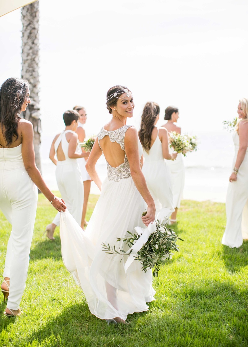 Bride with Bridesmaids, All in White
Photography: Samuel Lippke Studios
Read More:
http://www.insideweddings.com/weddings/a-rustic-camp-themed-outdoor-wedding/908/ Bride with keyhole back beaded wedding dress headdress bridesmaids in jumpsuits white