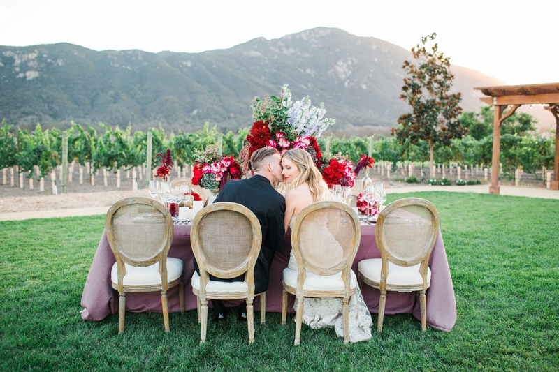 Couple Sits at Romantic Rustic Table on Vineyard
Photography: Jenny Quicksall Photography
Read More:
http://www.insideweddings.com/weddings/romantic-wedding-shoot-for-valentines-day-at-california-vineyard/751/ bride and groom kiss at romantic rustic table pink table linens red flowers california vineyard