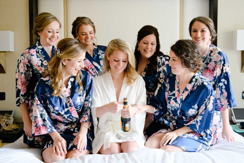 Bride with Champagne %26 Bridesmaid Robes
Photography: Studio This Is
Read More:
http://www.insideweddings.com/weddings/traditional-catholic-ceremony-elegant-reception-in-chicago/1206/ bride opening champagne bottle on bed with bridesmaids in matching flower print silk robes