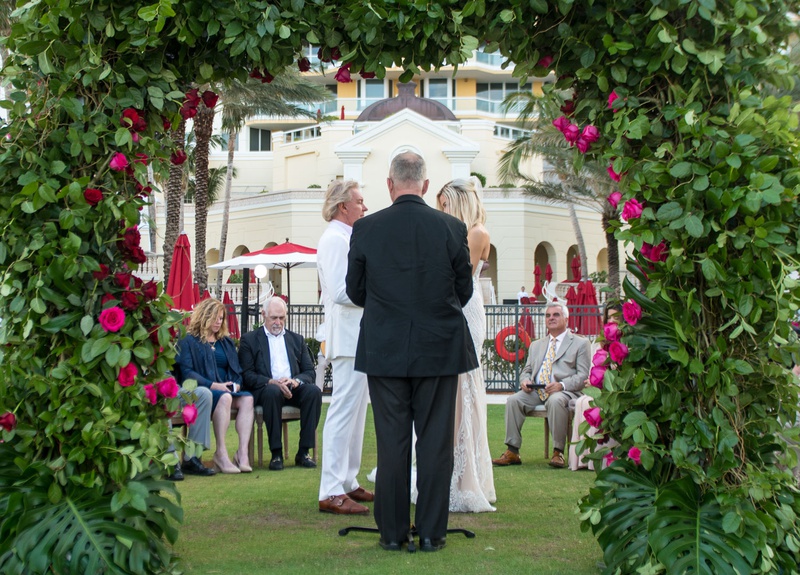 Ceremony View Through Archway
Photography: Suzanne Delawar Studios
Read More:
http://www.insideweddings.com/weddings/intimate-oceanfront-wedding-with-romantic-red-pink-white-palette/1235/ bride and groom with officiant at small ceremony acqualina resort and spa greenery arch pink roses