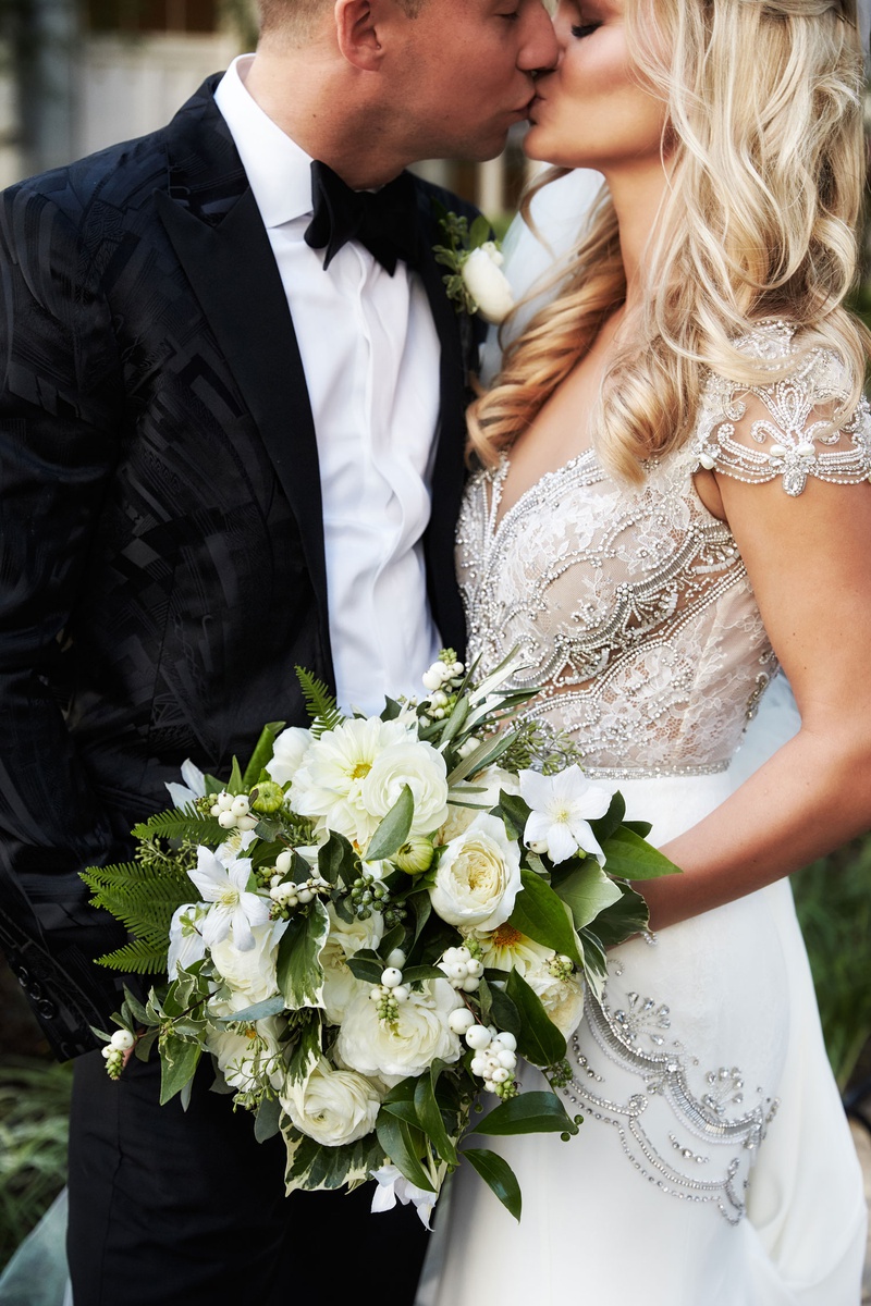 Bride %26 Groom Kiss with Bouquet
Photography: KingenSmith
Read More:
http://www.insideweddings.com/weddings/modern-romantic-wedding-with-glam-geometric-details-in-chicago/1171/ Bride in jewel cap sleeve wedding dress kissing groom bouquet white dahlia, ranunculus, garden rose