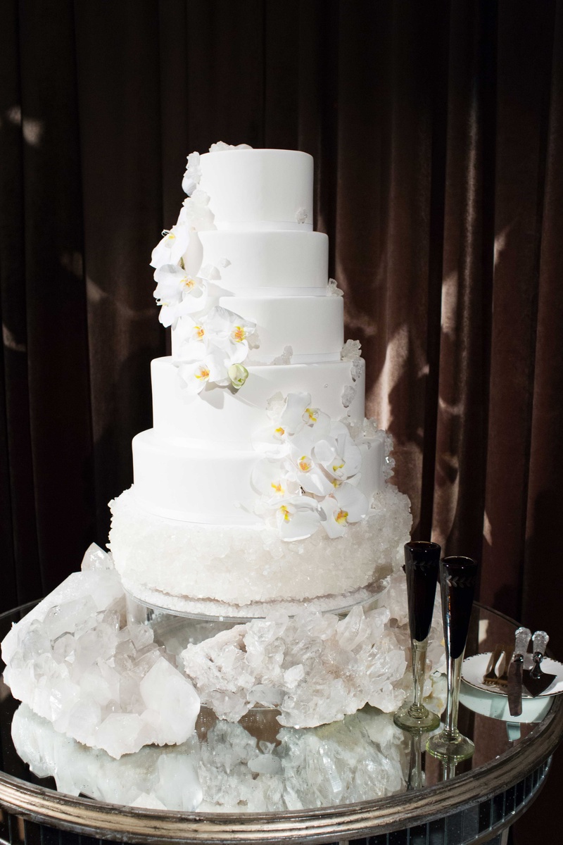 White Wedding Cake with Geode Base
Photography: Perez Photography
Read More:
http://www.insideweddings.com/weddings/incredible-tented-ceremony-barn-reception-at-ranch-in-aspen/860/ White wedding cake with fresh orchids and geode crystal bottom layer and cake table black champagne