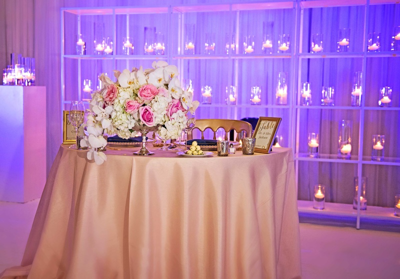Violet Lighting Behind Sweetheart Table
Photography: Carasco Photography
Read More:
http://www.insideweddings.com/weddings/church-ceremony-with-nigerian-traditions-chic-ballroom-reception/845/ sweetheart table with centerpiece white orchid ivory hydrangea pink rose and gold chairs purple
