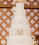 White %26 Gold Towering Cake
Photography: Shaun Menary Photography
Read More:
http://www.insideweddings.com/weddings/luxurious-hotel-wedding-texas-fair-themed-after-party-in-dallas/1241/ tall wedding cake with ivory flower topper and gold monogram design