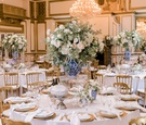 ballroom wedding reception round table gold chairs charger plates blue white chinoiserie vase white