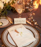 Single Orchid at Guest Place Setting
Photography: KingenSmith
Read More:
http://www.insideweddings.com/weddings/opulent-wedding-with-organic-textures-elegant-decor-in-chicago/1010/ Ornate wedding charger plate with menu and belly band with white orchid and low centerpieces