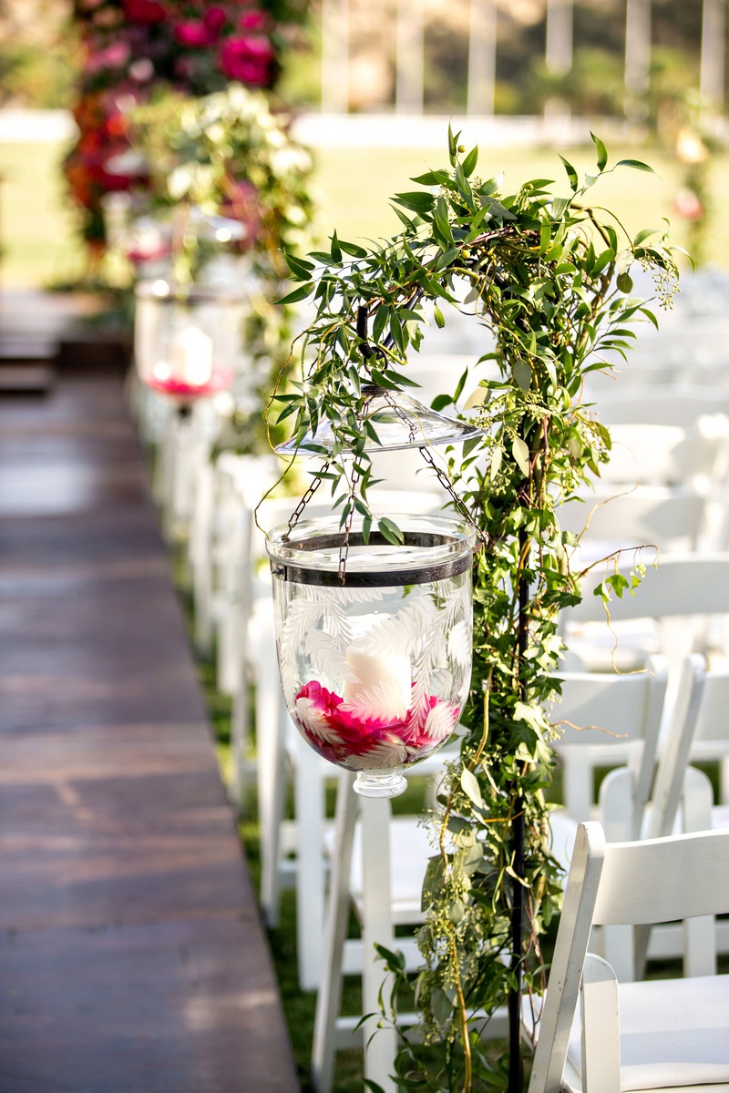 Etched Glass Ceremony Candleholder
Photography: Laurie Bailey Photography
Read More:
http://www.insideweddings.com/weddings/outdoor-jewish-ceremony-reception-with-colorful-bohemian-decor/1330/ wedding ceremony aisle etched glass candle holder on shepherd hook pink flower candles greenery
