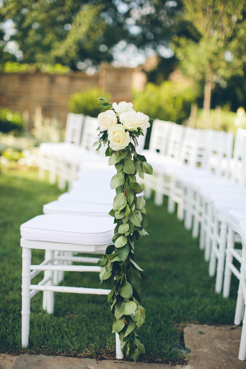 Elegant Aisle Marker
Photography: David %26 Tammy Molnar
Read More:
http://www.insideweddings.com/weddings/an-exquisite-backyard-wedding-in-tennessee/532/ White ceremony chairs adorned with leaf garlands