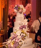 Six-Layer Cake with Purple Sugar Flowers
Photography: Ira Lippke Studios
Read More:
http://www.insideweddings.com/weddings/high-school-sweethearts-say-i-do-at-the-plaza-in-new-york-city/914/ Six layer wedding cake with purple white orchid peony rose sugar flowers cascading down side