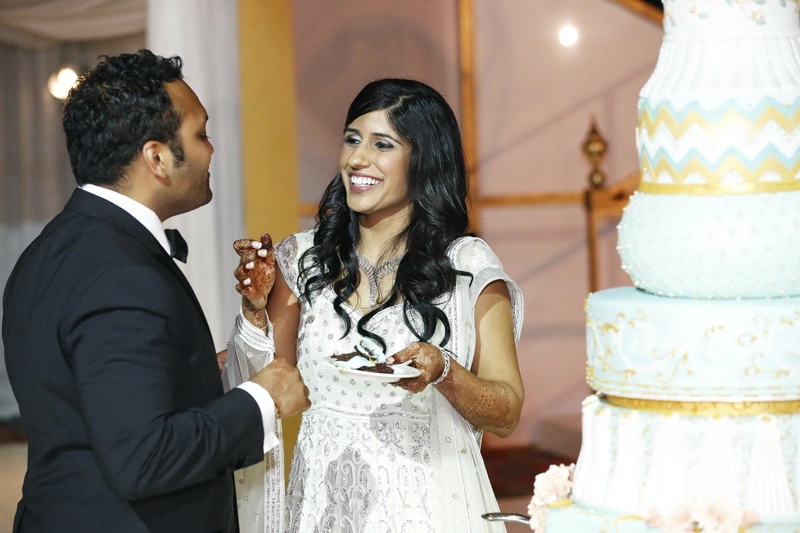 Bride and Groom Share Cake
Photography: Tomas Ramos Photographers
Read More:
http://www.insideweddings.com/weddings/houston-indian-wedding-celebration-with-800-person-guest-list/435/ Bride in a beaded gown shares cake with a groom in a black tuxedo