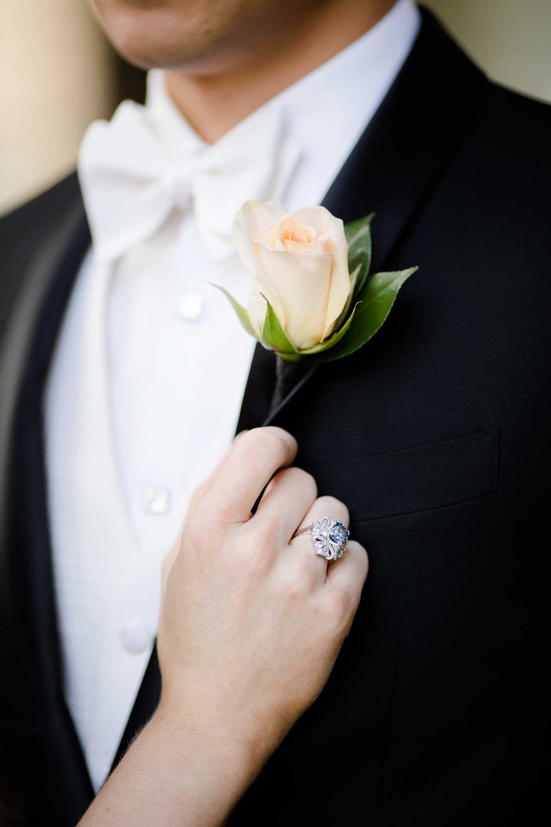 Groom's Peach Boutonniere
Photography: Studio This Is
Read More:
http://www.insideweddings.com/weddings/glamorous-city-style-real-wedding-at-a-luxury-hotel-in-chicago/1217/ groom in white bow tie with peach pink rose boutonniere bride vintage blue silver engagement ring