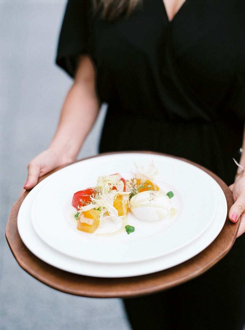 Burrata %26 Heirloom Tomato Salad
Photography: Branco Prata
Read More:
http://www.insideweddings.com/weddings/chic-destination-wedding-with-california-style-in-washington-dc/1042/ Wedding guest holding plate of salad course at spring wedding burrata cheese and heirloom tomato