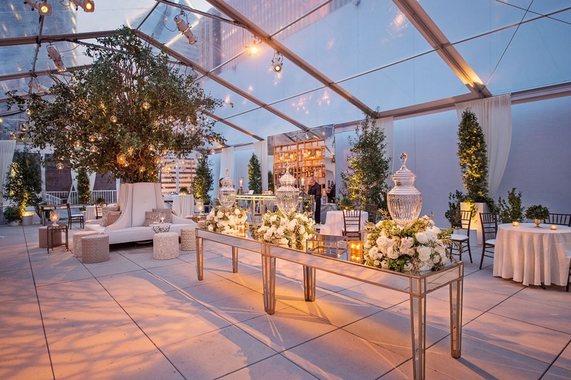 Cocktail Hour Space at Twilight
Photography: Carasco Photography
Read More:
http://www.insideweddings.com/weddings/traditional-ceremony-glamorous-garden-inspired-tented-reception/943/ Cocktail hour room clear top tent trees on both sides of escort card table
