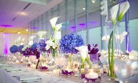 Modern Glass Centerpieces
Photography: Bob %26 Dawn Davis Photography
Read More:
http://www.insideweddings.com/weddings/modern-purple-blue-white-wedding-at-contemporary-chicago-venue/541/ Long wedding table with blue hydrangea and purple flowers