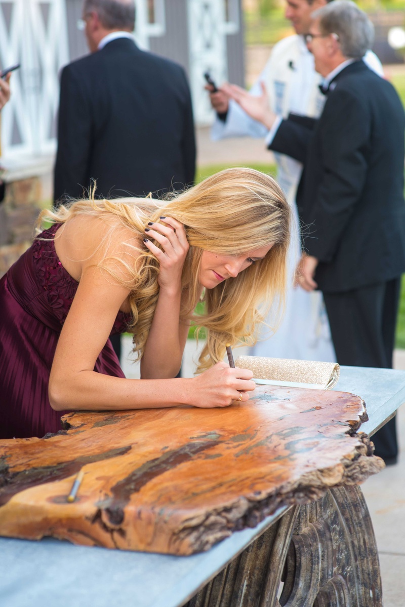Polished Wood Guest Book Alternative
Photography: Brett Butterstein Photography
Read More:
http://www.insideweddings.com/weddings/incredible-tented-ceremony-barn-reception-at-ranch-in-aspen/860/ Guest in burgundy dress signing slab of polished wood before or after wedding ceremony
