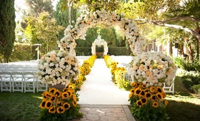 Garden Ceremony Décor
Photography: John Solano Photography
Read More:
http://www.insideweddings.com/weddings/summer-sunflower-ceremony-garden-inspired-reception/396/ Cream and peach roses and sunflowers along aisle
