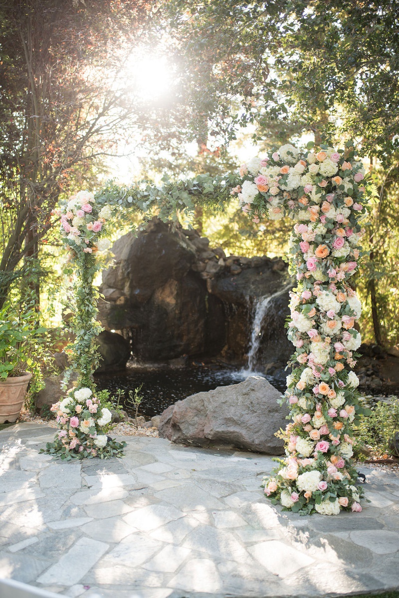 Peach %26 Pink Flowers on Ceremony Arch
Photography: Ashley Paige Photography
Read More:
http://www.insideweddings.com/weddings/elegant-outdoor-fall-wedding-at-a-rustic-chic-venue-in-malibu/1244/ wedding ceremony arch with pond and waterfall backdrop greenery white hydrangea pink orange roses