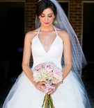 Bride in Halter Ball Gown with Blush %26 White Bouquet
Photography: Callaway Gable
Read More:
http://www.insideweddings.com/weddings/alfresco-summer-wedding-with-lush-foliage-accents-in-california/805/ bride in white tulle ball gown with plunging halter neckline looking down at blush ivory bouquet
