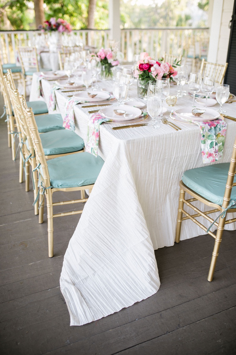 Pastel Chairs %26 Centerpieces
Photography: Vitor Lindo Photo + Video
Read More:
http://www.insideweddings.com/weddings/soft-romantic-spring-destination-wedding-in-south-carolina/1285/ wedding reception on porch white linen sage green mint cushions gold chairs pink pastel centerpiece