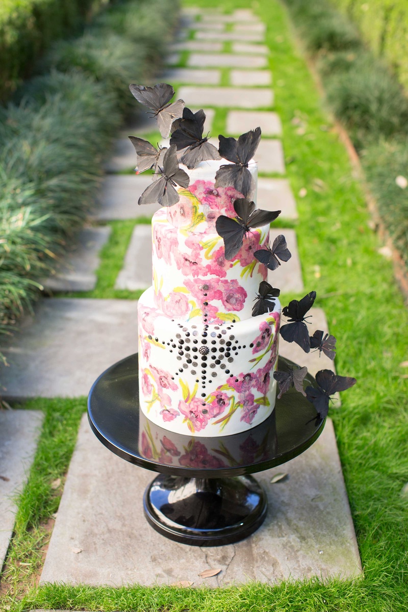 White Cake with Pink Floral Design and Black Butterflies and Jewels
Photography: Thisbe Grace Photography
Read More:
http://www.insideweddings.com/weddings/dramatic-wedding-shoot-inspired-by-alexander-mcqueen-chanel/749/ white cake with pink flower design and black jewels and black butterflies on top on stone path