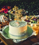 Small Cake with "The Best is Yet to Come" Topper
Photography: Juan Carlos Tapia Photography
Read More:
http://www.insideweddings.com/weddings/rustic-destination-wedding-with-touching-details-on-beach-in-mexico/801/ a small white wedding cake with icing patterns and a topper that reads the best is yet to come