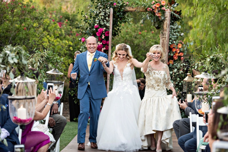 Bride Running Up Aisle with Parents
Photography: Laurie Bailey Photography
Read More:
http://www.insideweddings.com/weddings/outdoor-jewish-ceremony-reception-with-colorful-bohemian-decor/1330/ mother of bride gown drop waist badgley mischka father of bride in blue suit yellow tie outdoor