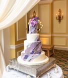 Wedding Cake with Artistic Design
Photography: Mantas Kubilinskas Photography
Read More:
http://www.insideweddings.com/weddings/sophisticated-ceremony-ballroom-reception-in-washington-dc/1296/ wedding cake four layer with purple blue grey brush stroke design and flowers on top silver base