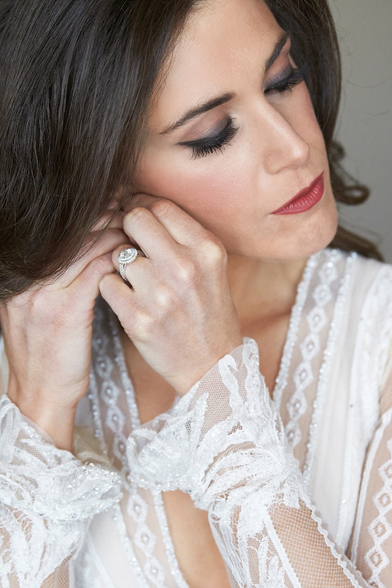 Bride Putting on Earring with Bold Makeup
Photography: KingenSmith
Read More:
http://www.insideweddings.com/weddings/an-opulent-spring-wedding-with-timeless-elegant-decor-in-chicago/1007/ Elegant wedding day makeup dark lip and smokey eye double halo engagement ring inbal dror dress