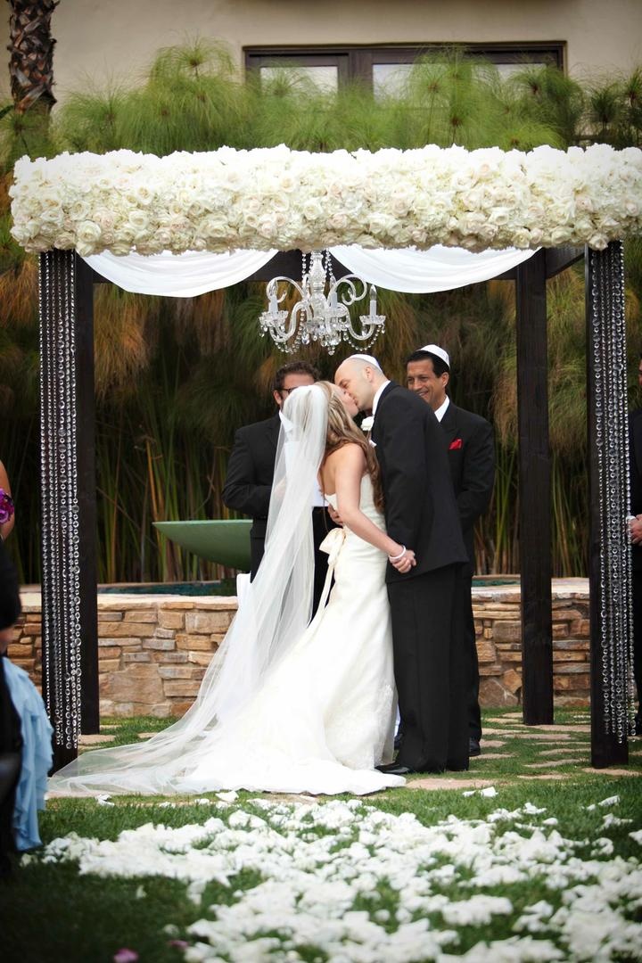 Crystal Wedding Chuppah
Photography: Darin Fong Photography
Read More:
http://www.insideweddings.com/weddings/outdoor-ceremony-purple-and-white-ballroom-reception/372/ White rose chuppah with chandelier and crystal strands