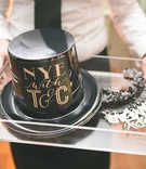 New Year's Eve Favor Ideas
Photography: Rob and Wynter Photography
Read More:
http://www.insideweddings.com/weddings/mlb-players-white-black-gold-nye-ballroom-wedding-in-atlanta/806/ Wedding favors on acrylic tray for NYE wedding black party hat, gold noisemaker, silver headpiece