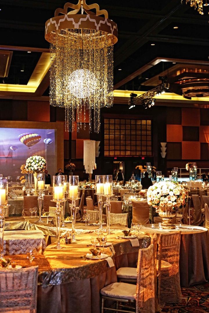 Reception Décor
Photography: Tomas Ramos Photographers
Read More:
http://www.insideweddings.com/weddings/houston-indian-wedding-celebration-with-800-person-guest-list/435/ Wedding reception with tables covered in gold tablecloths and topped with tall candleholders