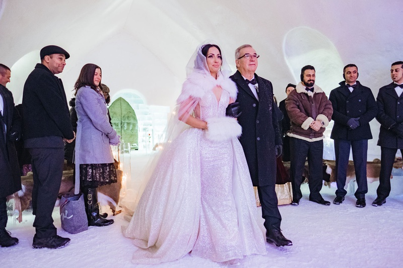 Ice Castle Wedding Ceremony Processional
Photography: Joel %26 Justyna
Read More:
http://www.insideweddings.com/weddings/dreamy-winter-destination-wedding-in-an-ice-castle-in-quebec-city/1270/ bride in sparkle wedding dress overskirt with fur hand muff and cape walking with father guest coats