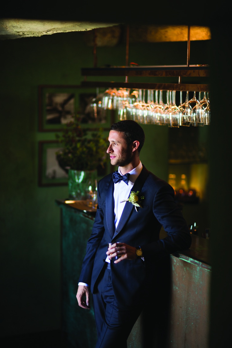 Groom Leaning Against Bar
Photography: The Day by Ira Lippke
Read More:
http://www.insideweddings.com/weddings/romantic-ceremony-on-bluff-tented-reception-in-tuscany/1311/ groom in navy armani suit and matching bow tie leans against bar