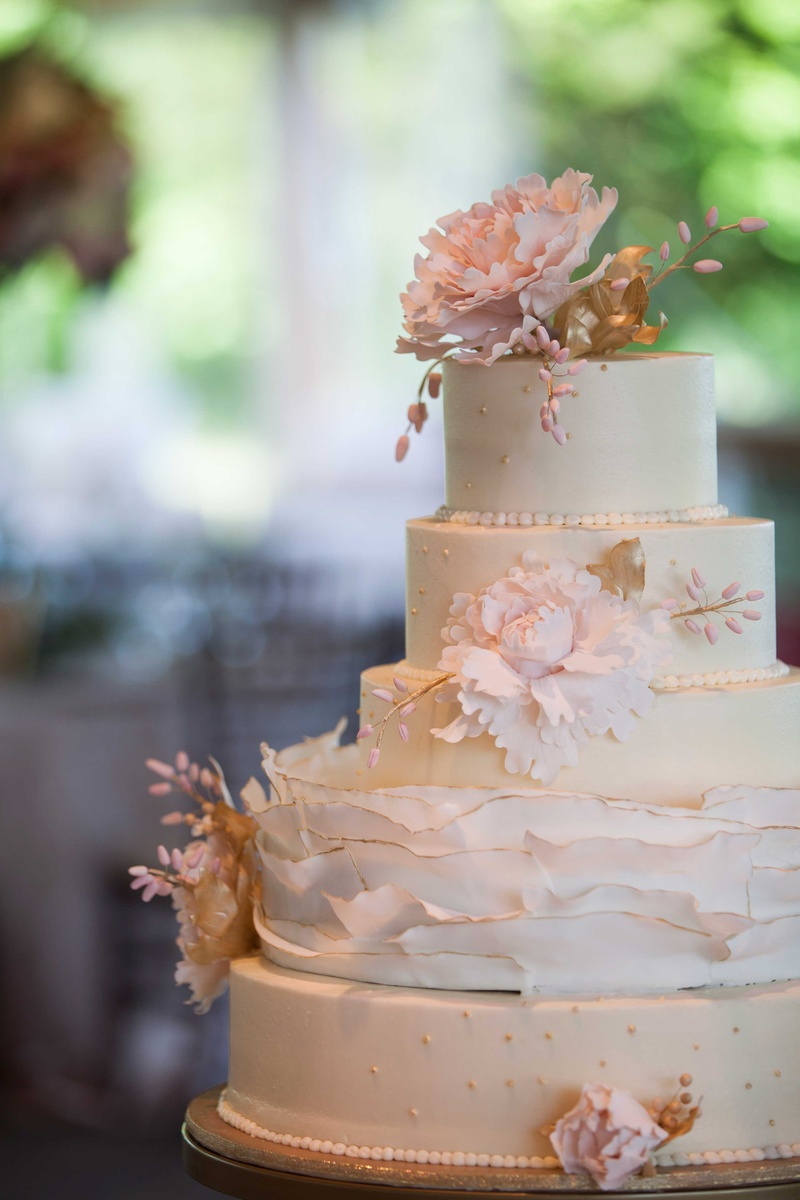 White Wedding Cake with Pink Floral Details
Photography: Michael Bambino %26 Co.
Read More:
http://www.insideweddings.com/weddings/whimsical-open-air-secret-garden-wedding-with-soft-spring-hues/777/ delicate five tier white wedding cake with pink flowers and gold detailing ruffles
