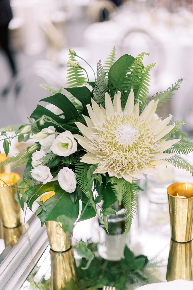 Tropical Fern %26 Protea Centerpiece
Photography: Lauren Gabrielle Photography
Read More:
http://www.insideweddings.com/weddings/summer-real-wedding-featuring-tropical-decor-at-an-art-museum/1328/ low wedding centerpiece king protea white flower monstera leaf fern gold candle votives tropical