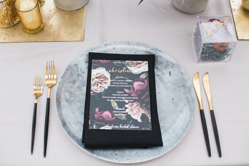 Concrete-Style Charger Plate
Photography: Jessica Claire Photography
Read More:
http://www.insideweddings.com/weddings/unique-chic-bridal-shower-with-dark-and-moody-color-scheme/1335/ bridal shower with grey charger plate designed to look like concrete, gold flatware black handles