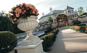 Ceremony Decor
Photography: Jay Lawrence Goldman Photography
Read More:
http://www.insideweddings.com/weddings/a-sophisticated-tented-estate-wedding-in-california/179/ An urn full of pink, peach, and red roses decorates the start of a wedding aisle