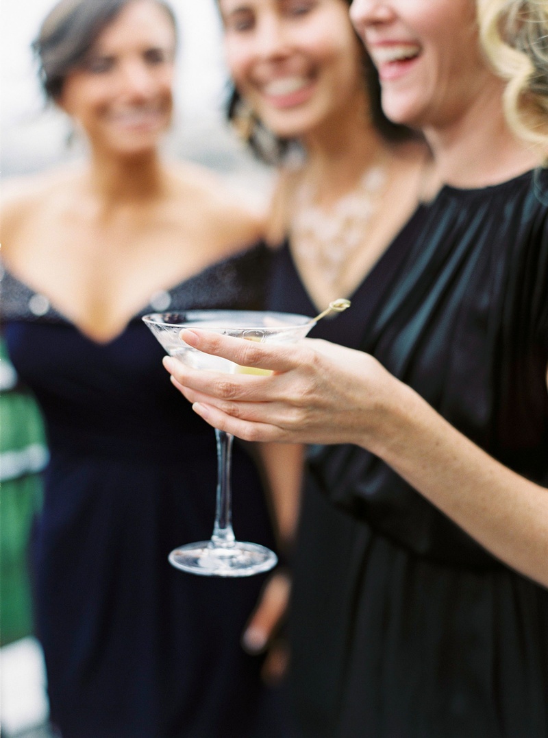 Guest Holding Martini Glass
Photography: Branco Prata
Read More:
http://www.insideweddings.com/weddings/chic-destination-wedding-with-california-style-in-washington-dc/1042/ Wedding guest in black dress holding martini glass with olive at cocktail hour reception