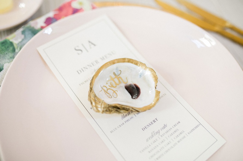 Oyster Shell Place Card for Guests
Photography: Vitor Lindo Photo + Video
Read More:
http://www.insideweddings.com/weddings/soft-romantic-spring-destination-wedding-in-south-carolina/1285/ wedding guest place setting light pink plate with gold rim and calligraphy oyster shell place card