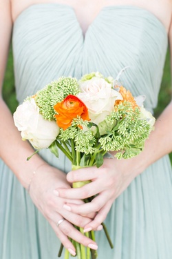 Photography: Cassi Claire Photography
Read More:
http://www.insideweddings.com/inspiration/board/217/iwadmin2/outstanding-orange-wedding-details/ Bridesmaid in a seafoam J.Crew dress holds bouquet of white roses, red orange ranunculus and greener